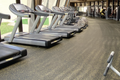 Row of treadmills on gym flooring