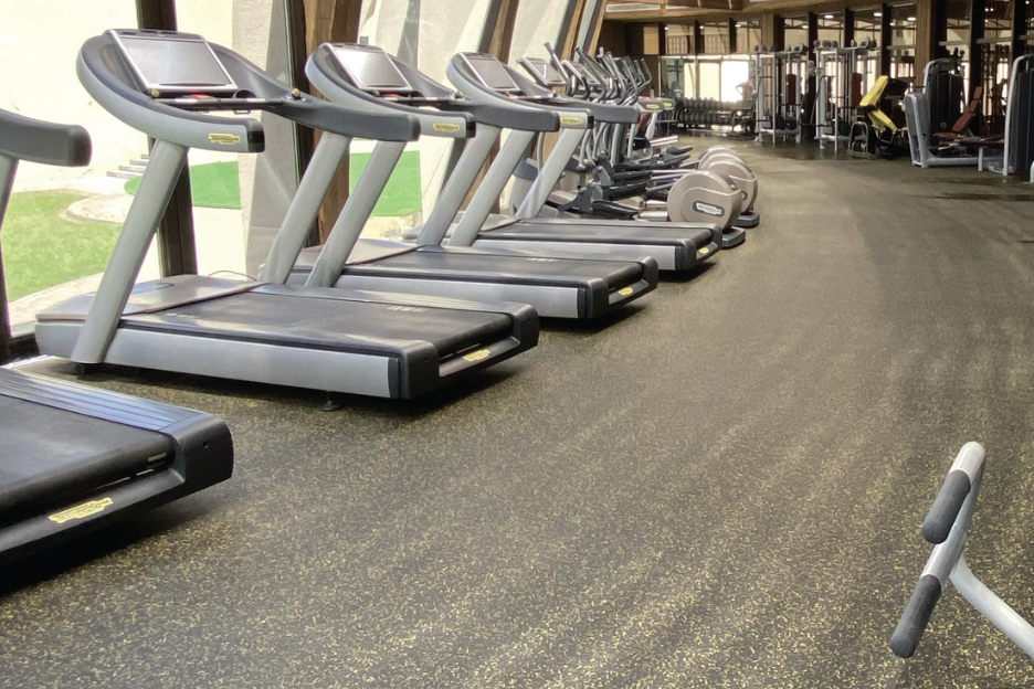 Row of treadmills on gym flooring