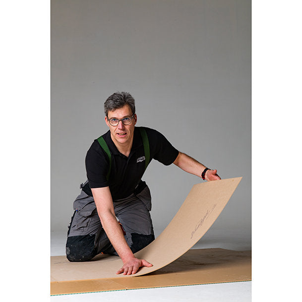 Installer laying Jumpax overlay board for LVT floor preparation