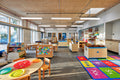 A bright children's activity room with multiple light wooden Troldtekt panels applied to the ceiling for a natural minimalistic aesthetic