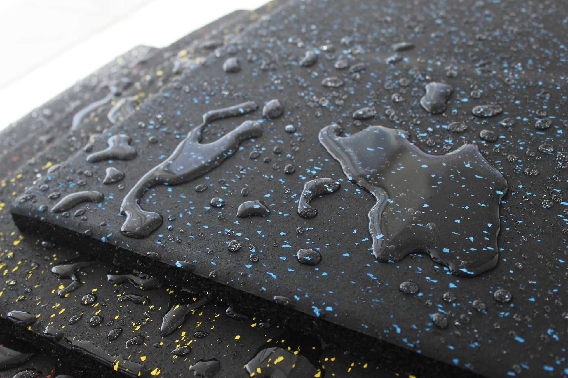 Close-up of TerraFit Duo gym tile with water beading, showing water-resistant properties.